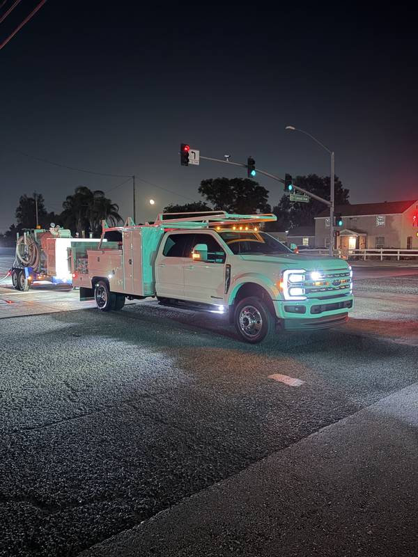 Response truck and equipment trailer staged at an intersection at night